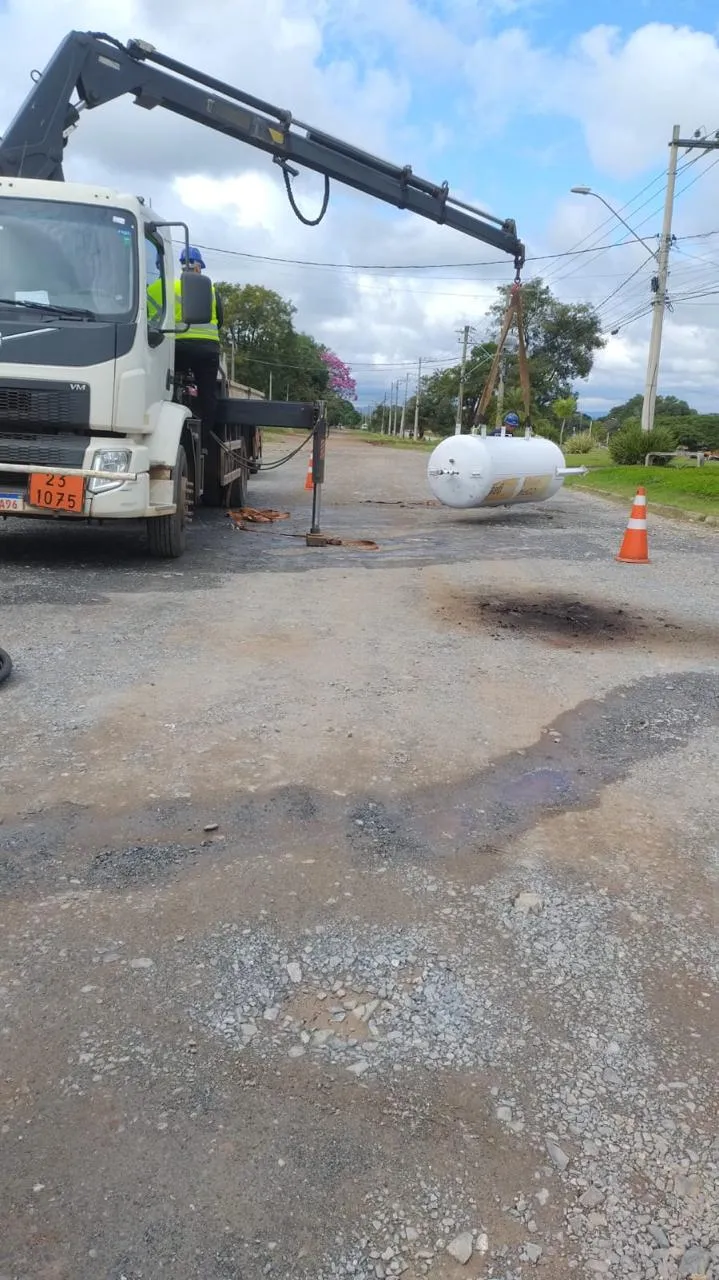 Caminhão munck da Frota Zulos içando tanque pequeno em via pública